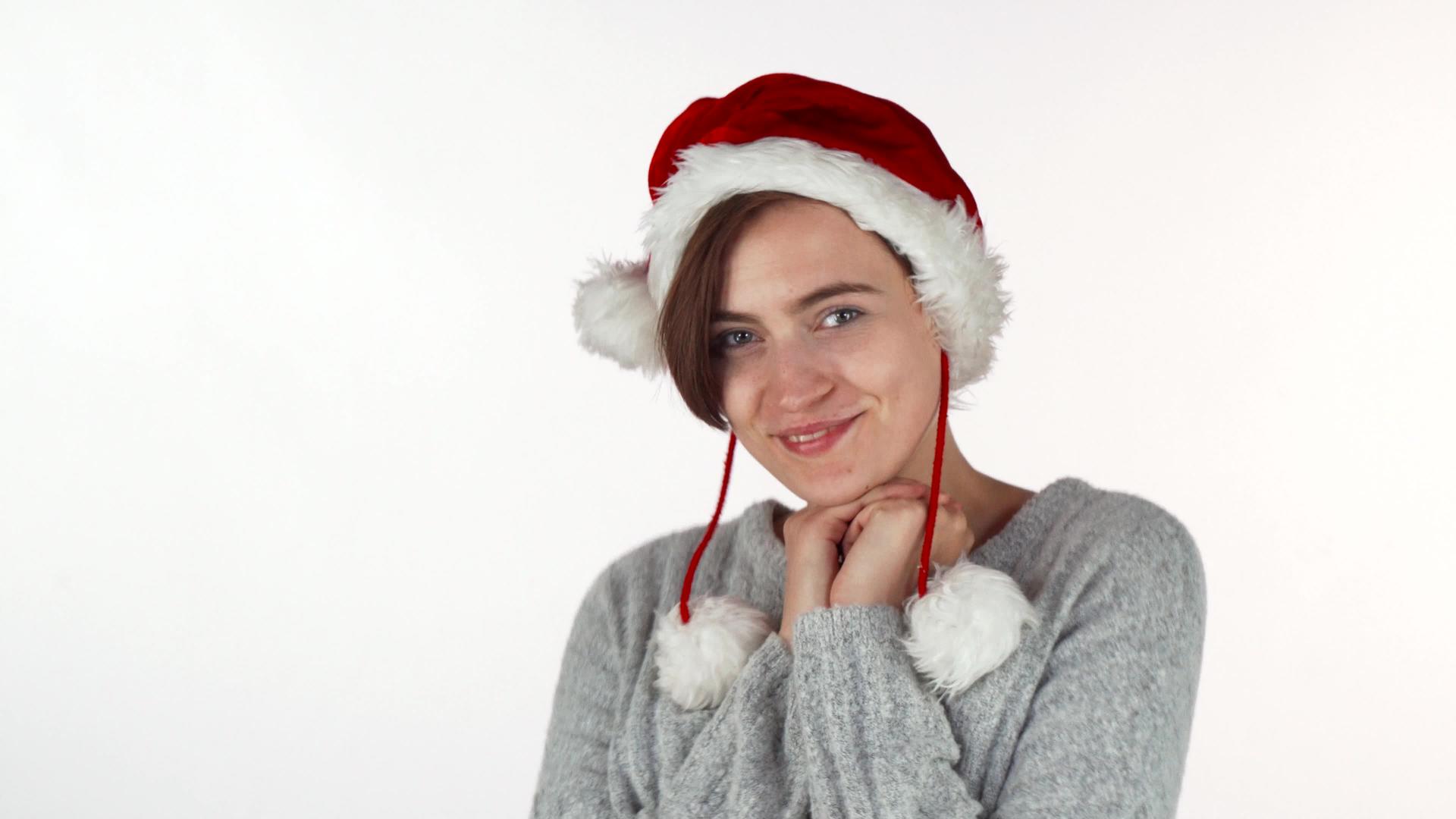 一个穿着圣诞帽的美丽快乐的女孩对着镜头微笑视频的预览图