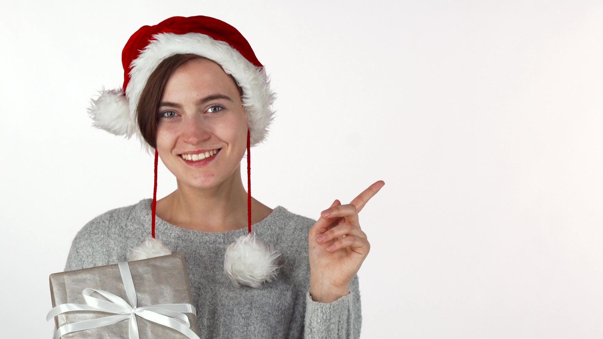 快乐美丽的女人戴着圣诞帽拿着礼物视频的预览图
