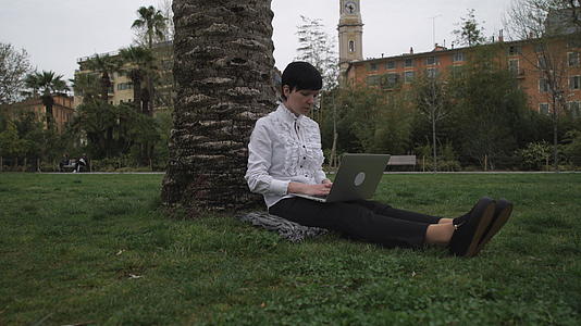 在公园工作的妇女在开放式空气计算机上工作视频的预览图