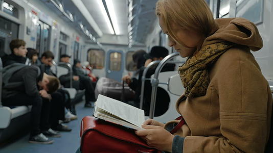 地铁里的年轻妇女看书视频的预览图