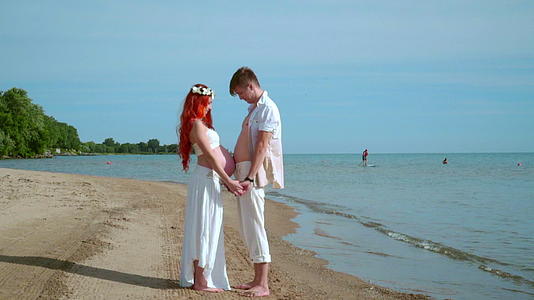 丈夫在海边摸妻子的孕肚视频的预览图