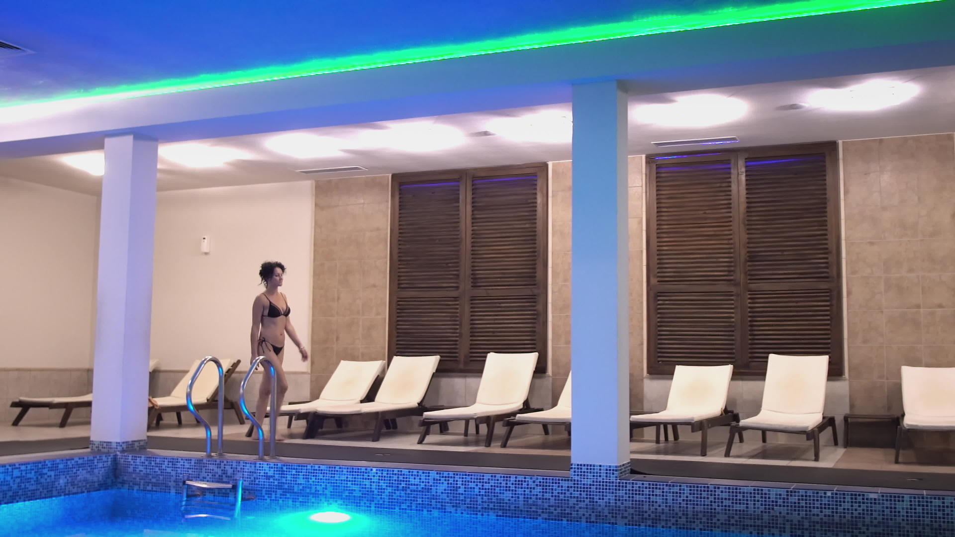 比基尼优雅的瘦女人走在温泉游泳池里视频的预览图