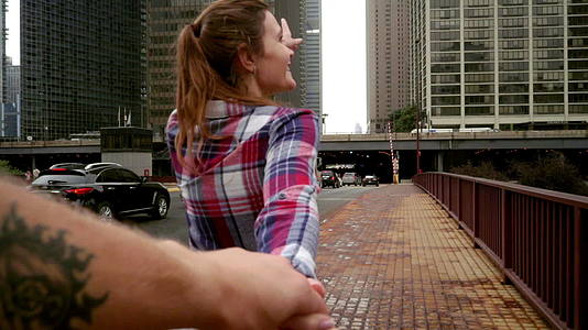 年轻女性向我展示现代城市摩天大楼的美景视频的预览图