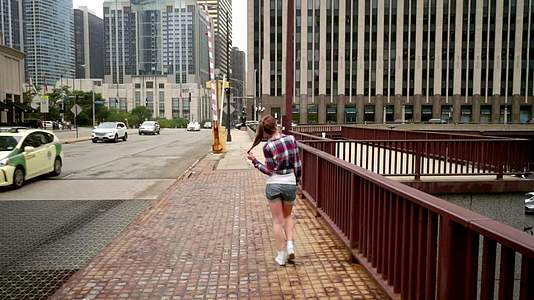 穿着临时服装的年轻妇女走在城市街头视频的预览图