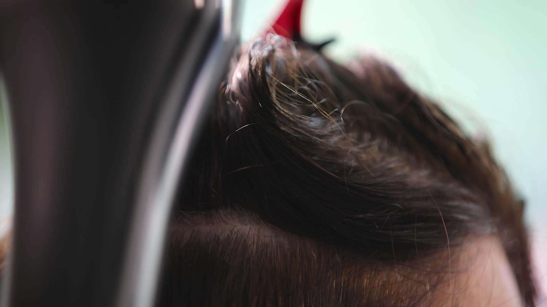 理发师用理发机和梳子擦女人的头发视频的预览图