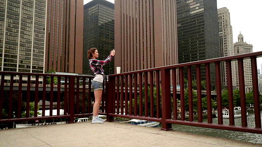 现代城市摩天大楼移动照片中的年轻美女视频的预览图