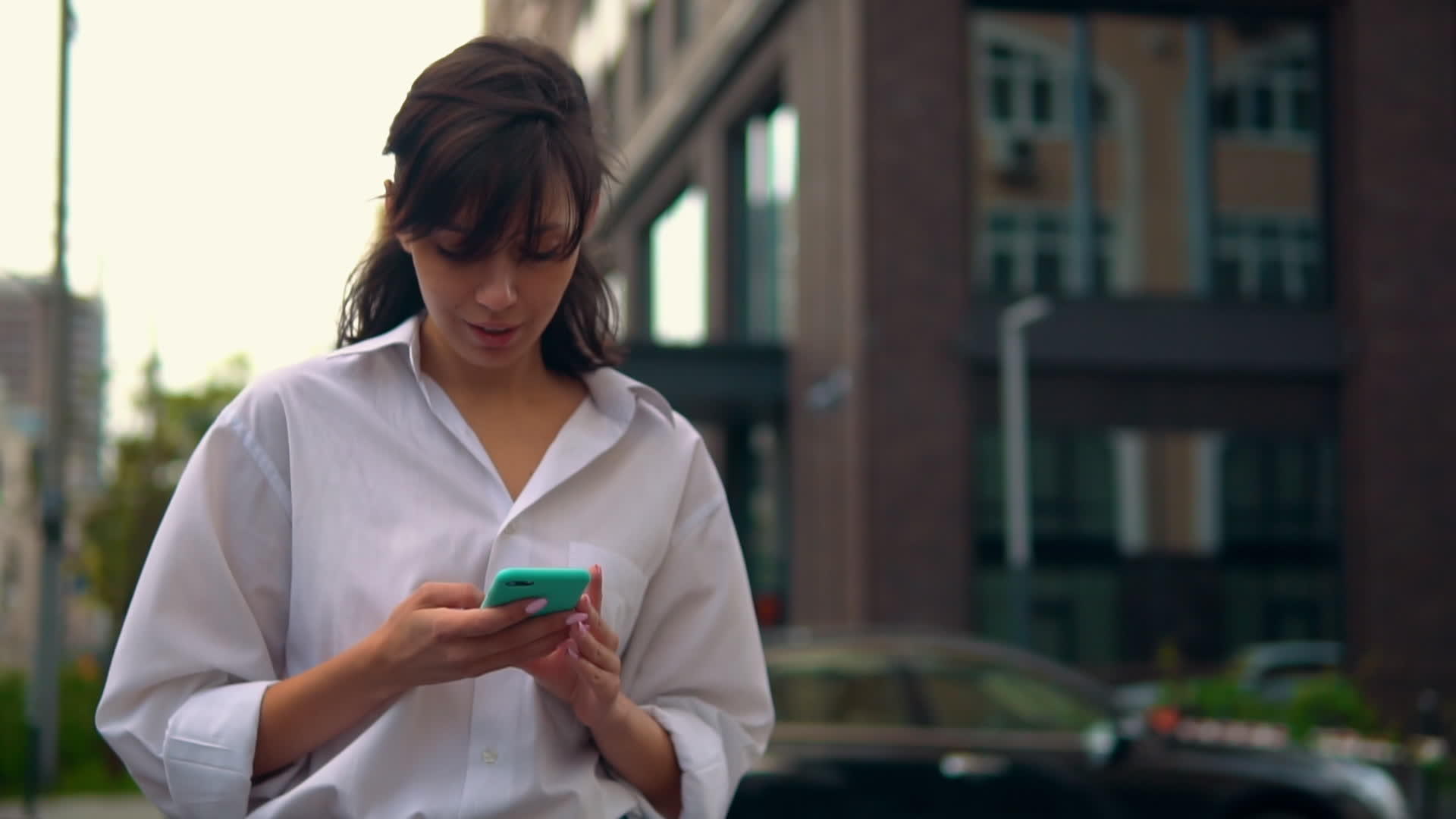 使用智能手机在城市中行走caucasians女人视频的预览图