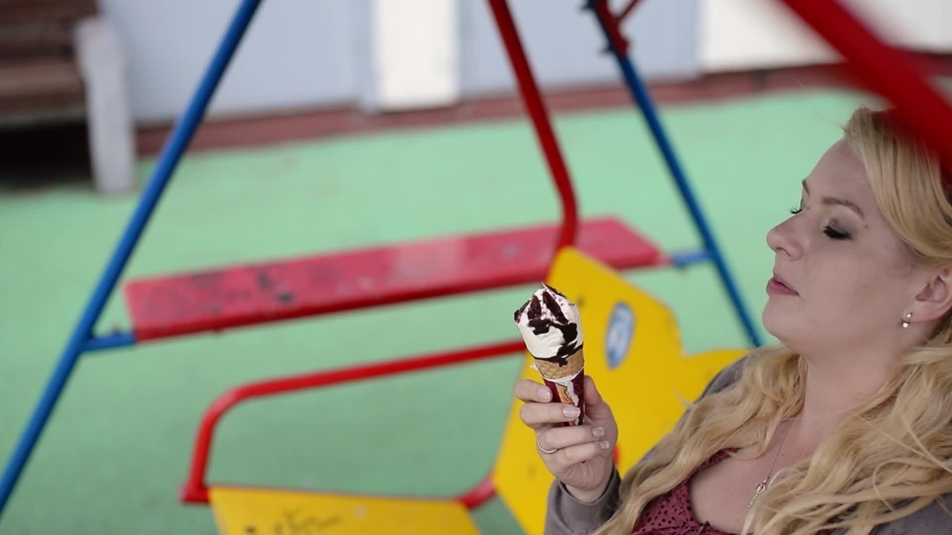 摇摆时吃和舔冰淇淋的金发美女视频的预览图