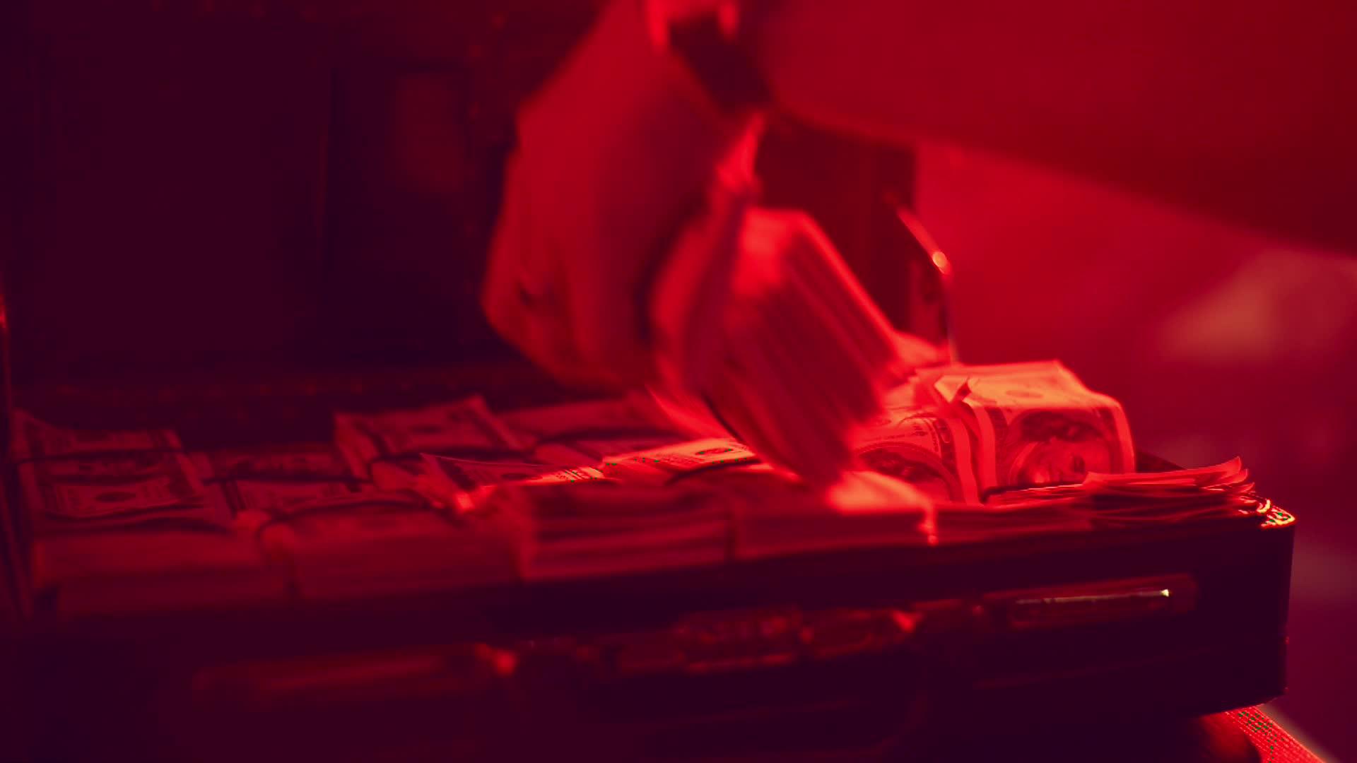 男人用手从红色背光的箱子里拿钱装满钱视频的预览图