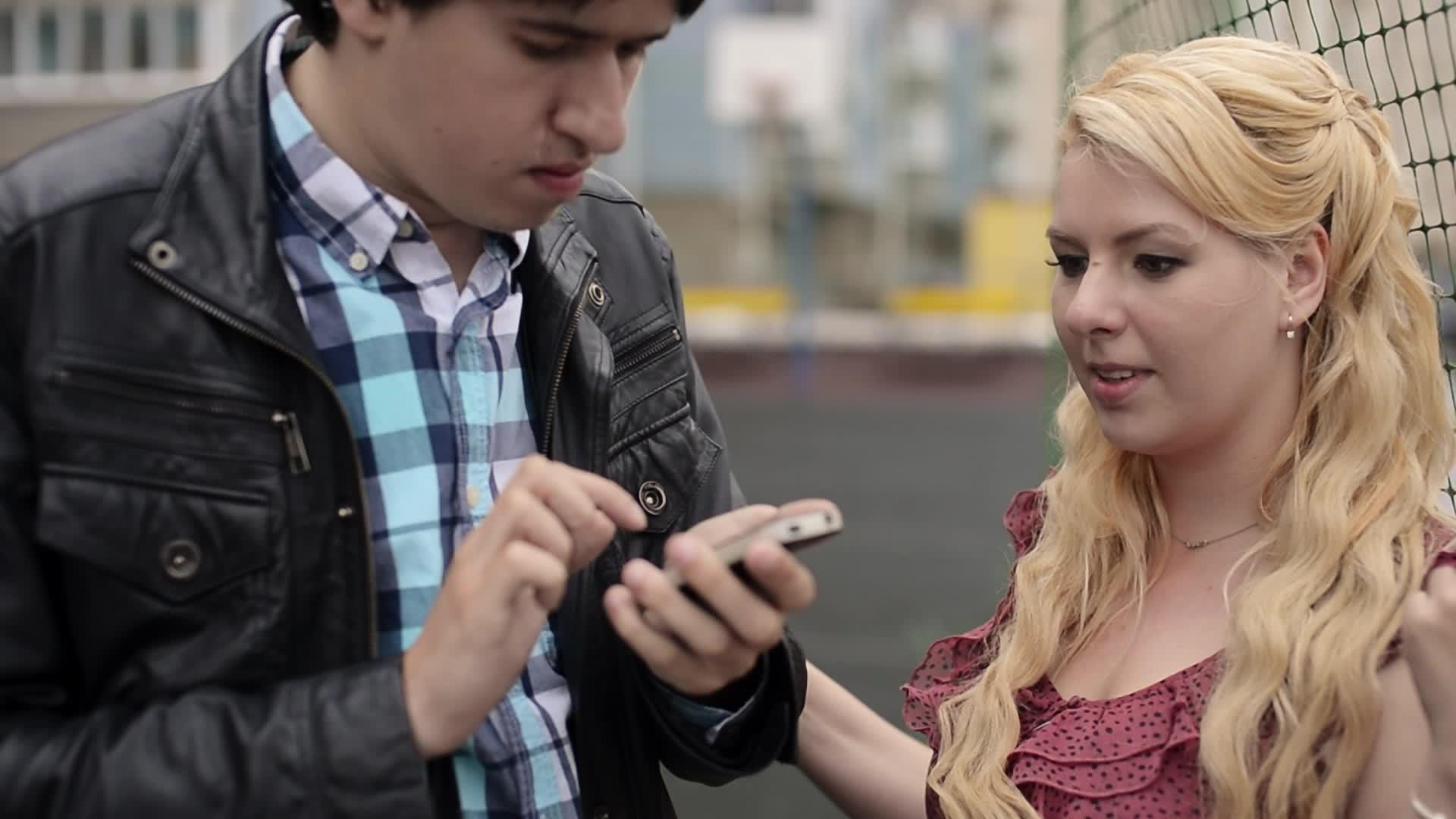 年轻的年轻人用手机拍照他的女朋友玩得很开心视频的预览图