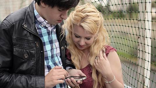 年轻男青年用手机拍下了女友的照片视频的预览图