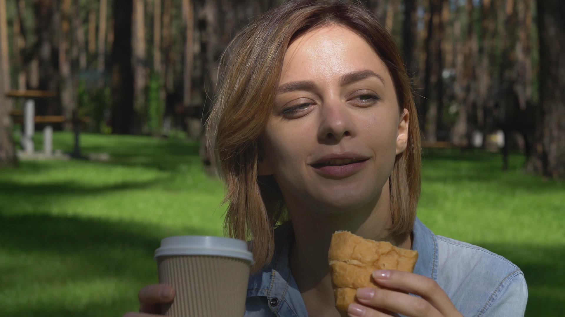 女性在露天吃面包产品视频的预览图
