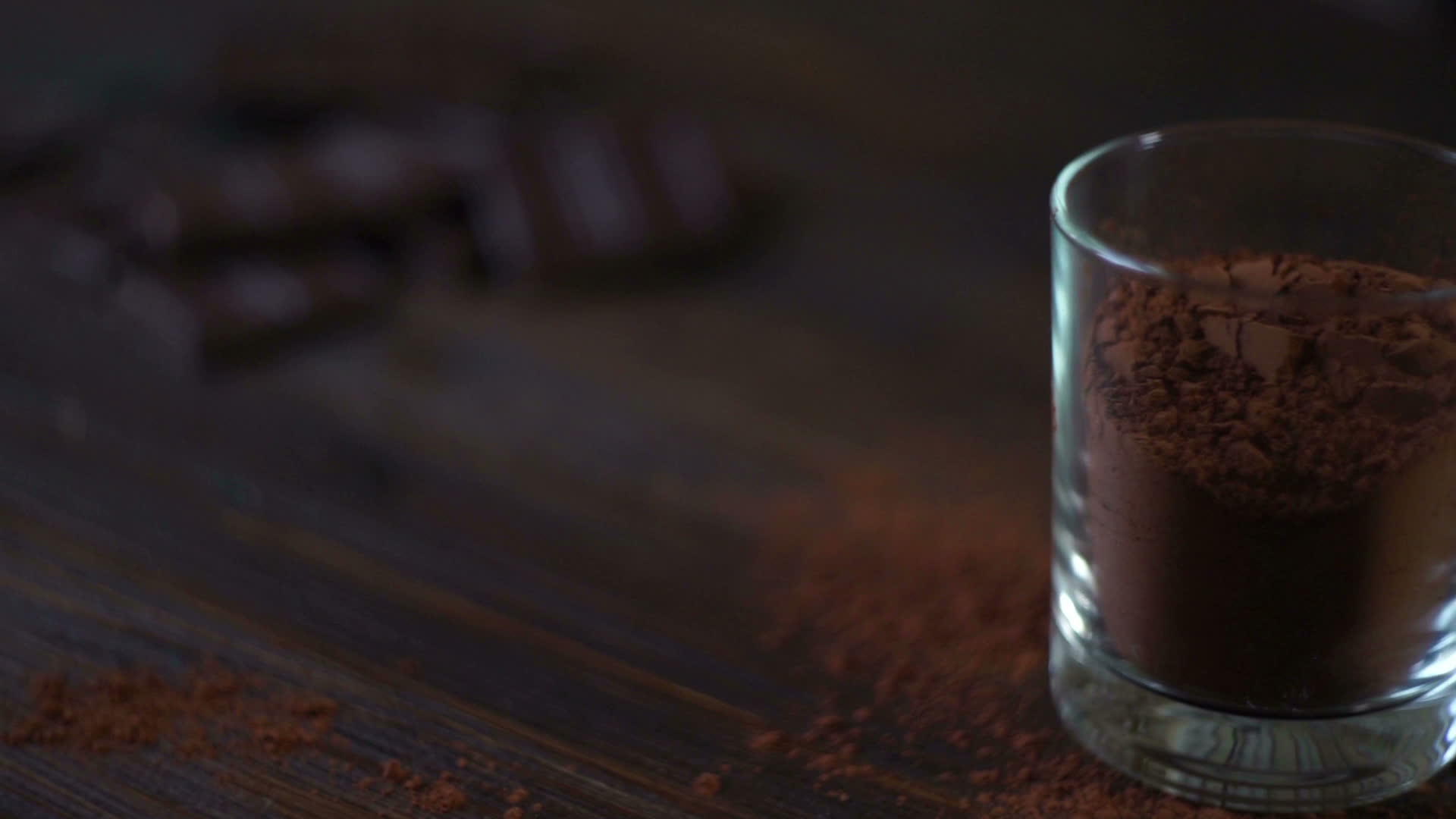 木桌上的黑巧克力棒和玻璃可粉视频的预览图