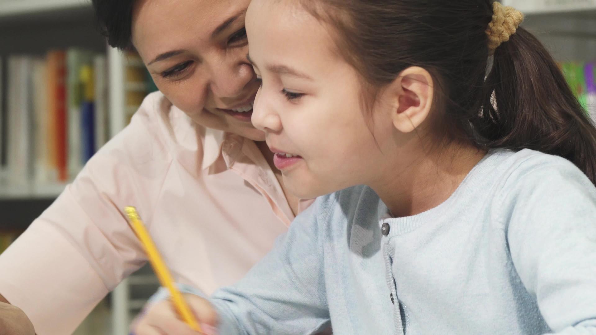 一个可爱的小女孩和她的母亲一起学习视频的预览图