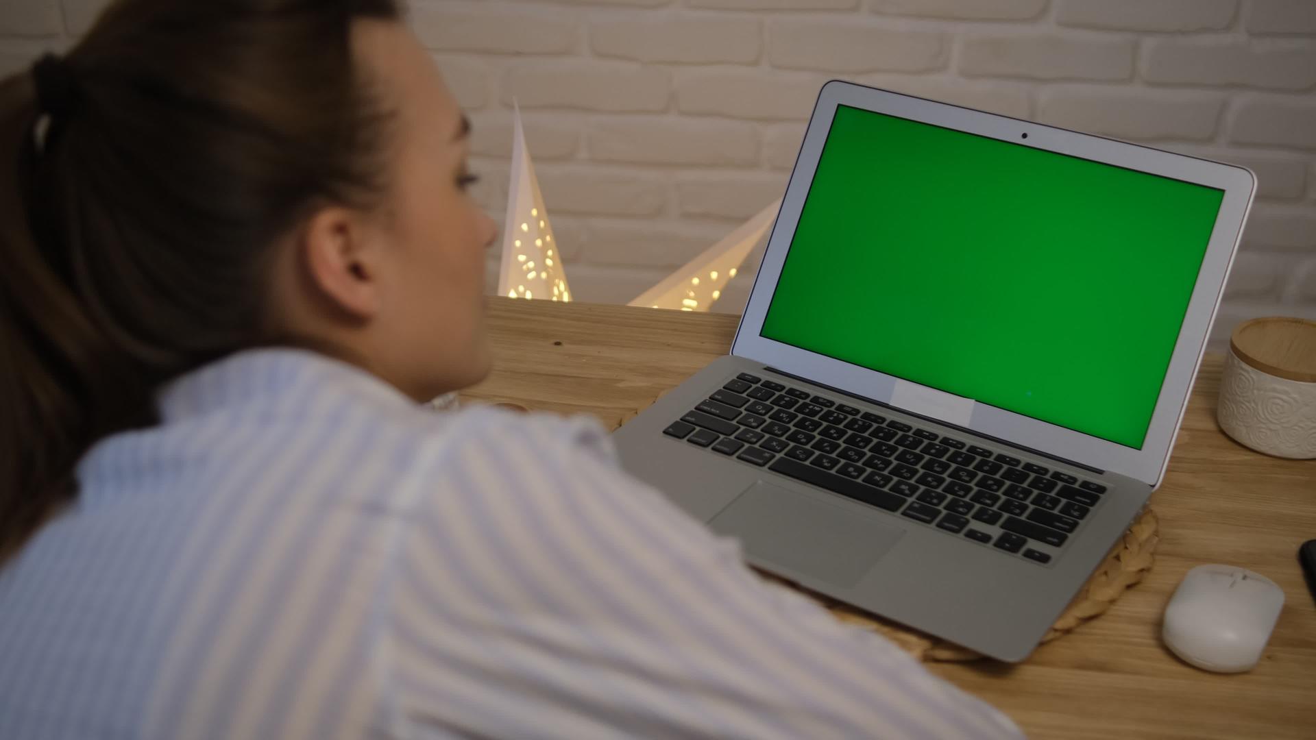 远程学习工作的概念绿色电脑屏幕女孩坐在桌子旁边远程学习视频的预览图