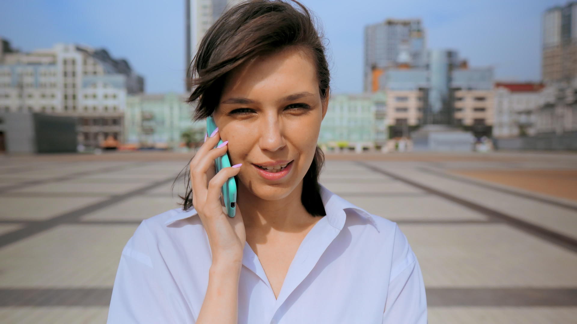 在城市背景下使用手机的快乐微笑的女性视频的预览图