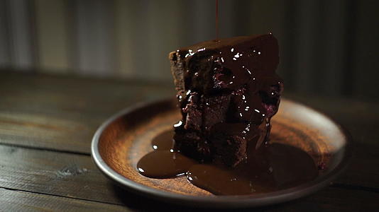 巧克力在蛋糕上流动巧克力滴在甜点上视频的预览图