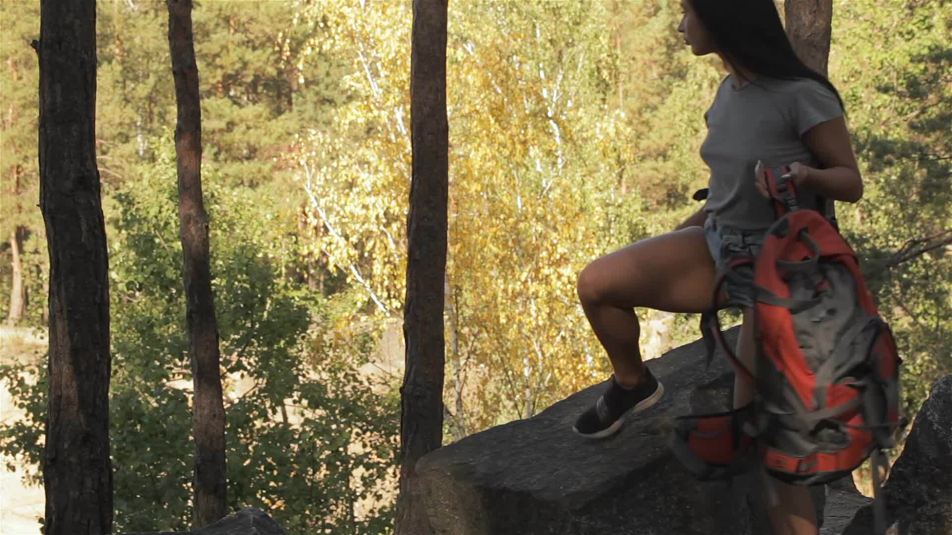 坐在岩石上的女性徒步旅行者视频的预览图