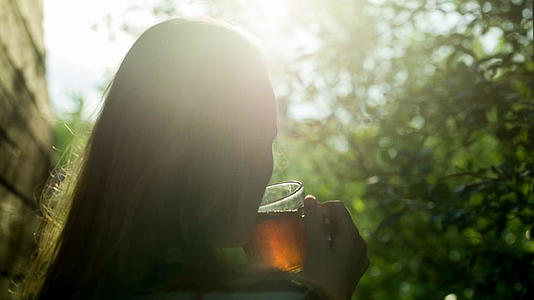 日落时在户外喝热茶的女孩视频的预览图