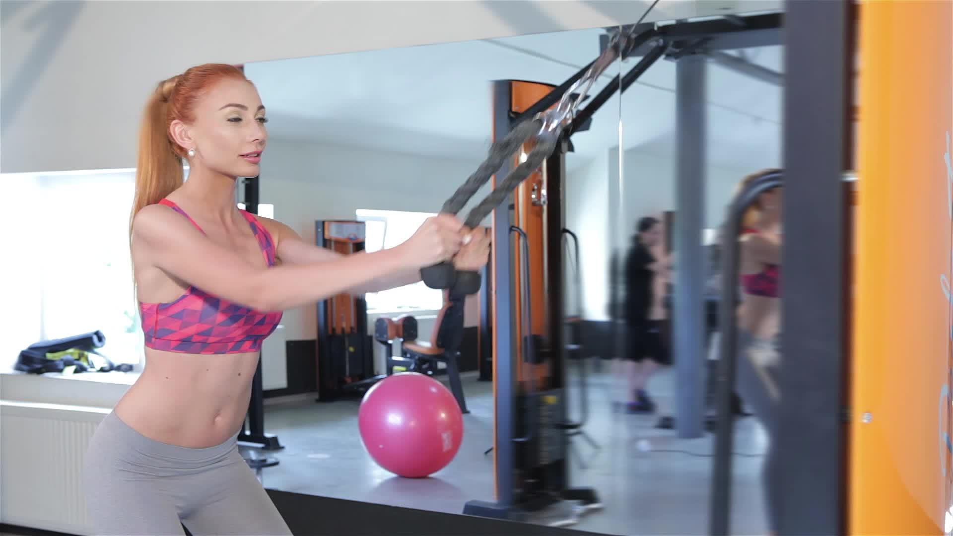 一健身中心的健身机绳拉到大腿上的女人视频的预览图