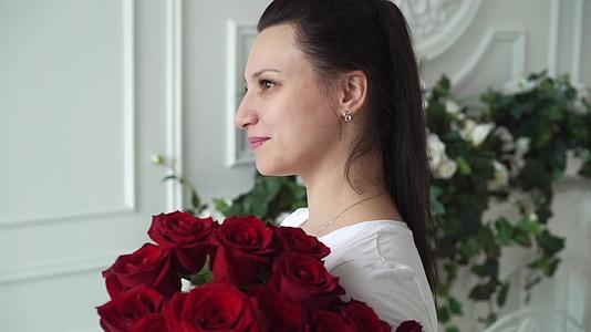 年轻女子红玫瑰束视频的预览图