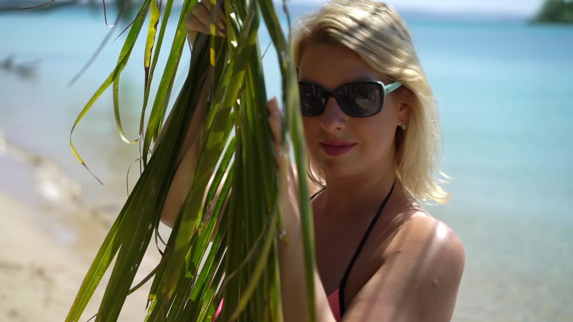 年轻女性在海滩上穿着粉色泳衣视频的预览图