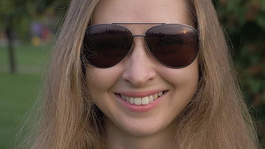 年轻caucasiansian微笑和牙齿女人在公园里视频的预览图