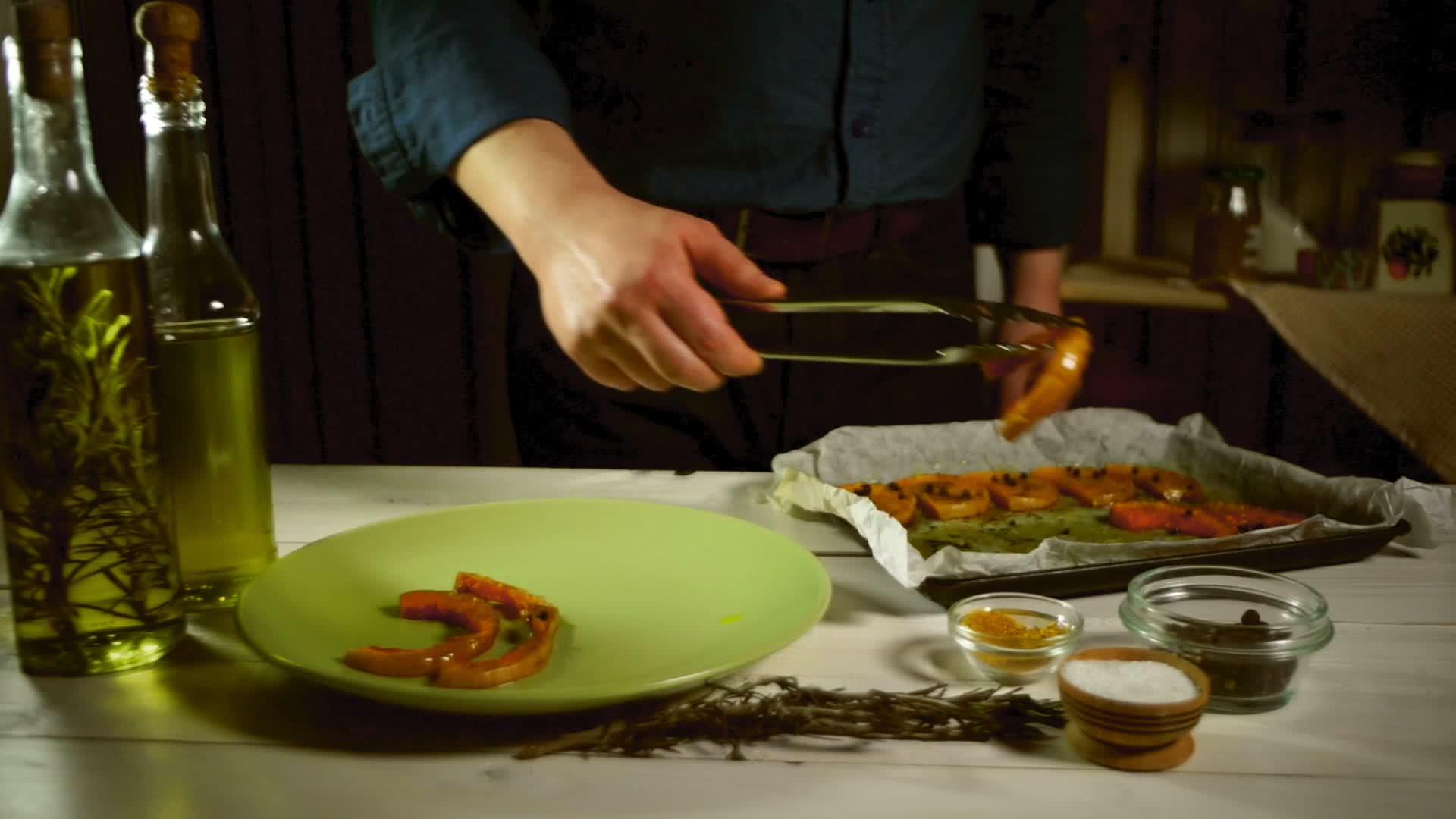 厨师把烤南瓜片放在盘子上把烤菜放在生锈的厨房里视频的预览图