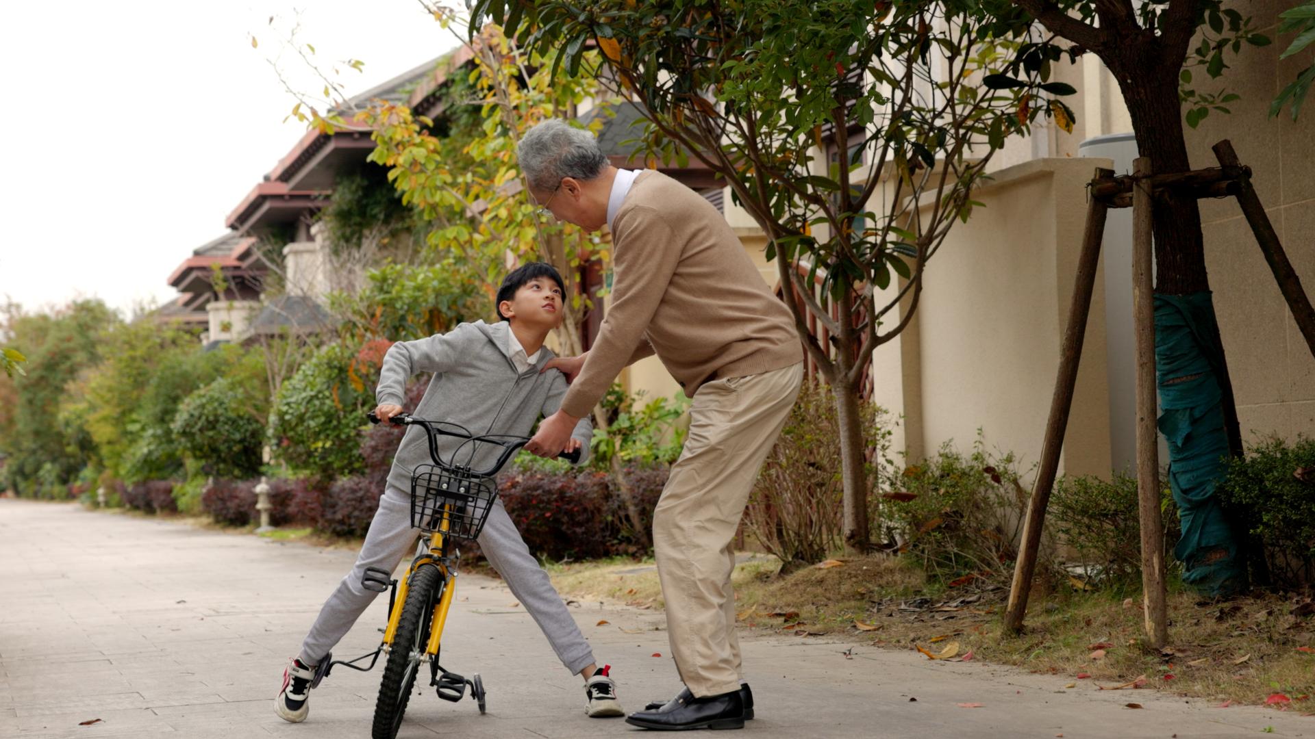 爷爷保护骑自行车的孙子视频的预览图
