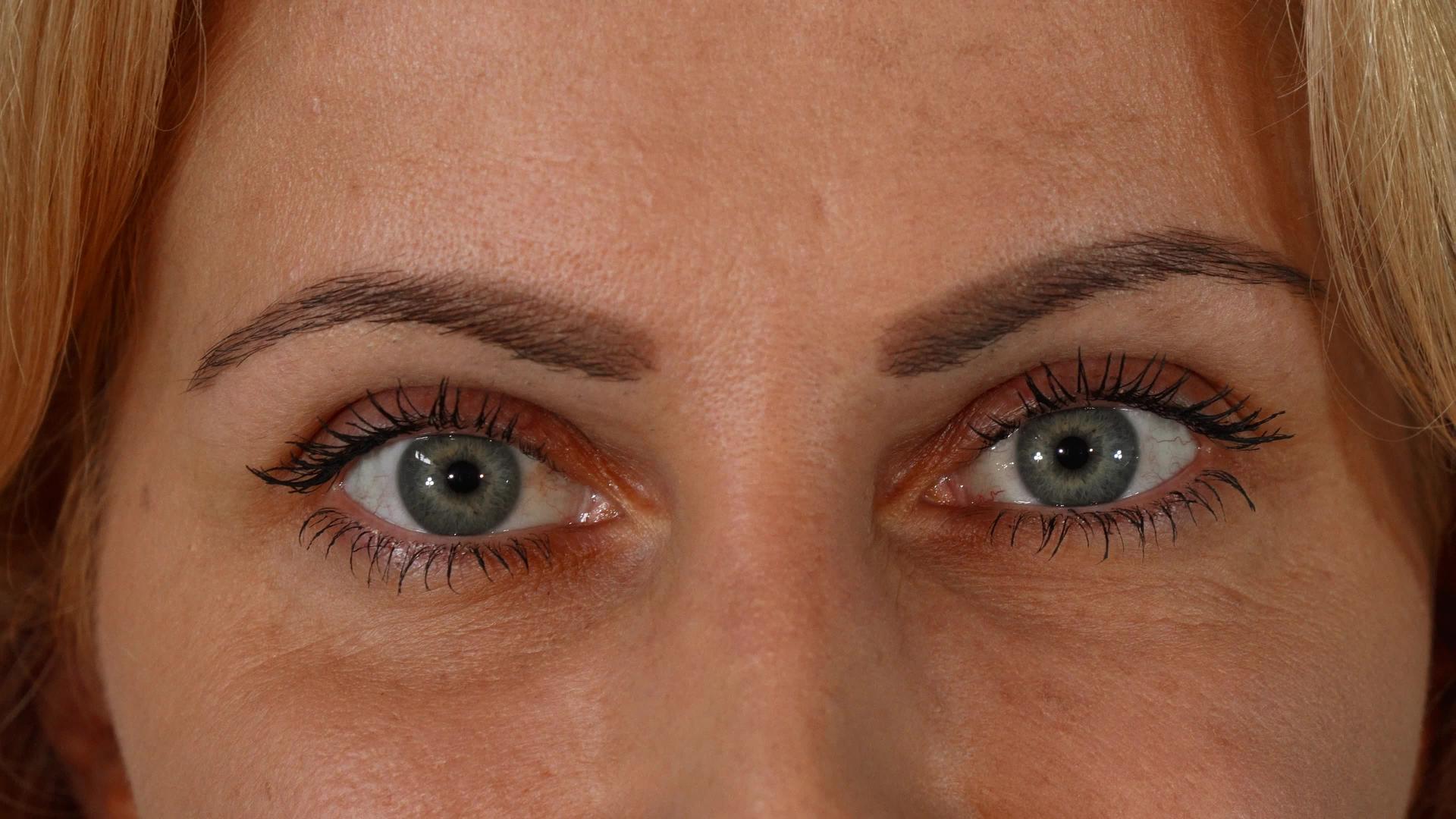一个成熟的女人美丽的蓝眼睛看着镜头视频的预览图