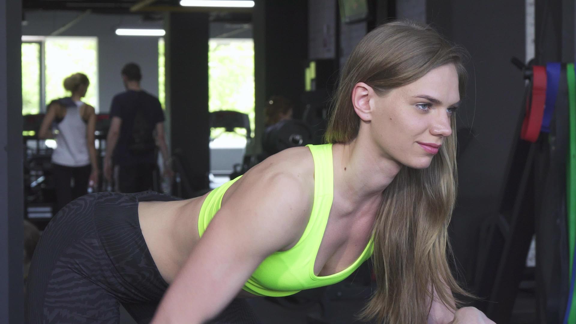 美丽美丽的女运动员开心地用重量和体力锻炼视频的预览图