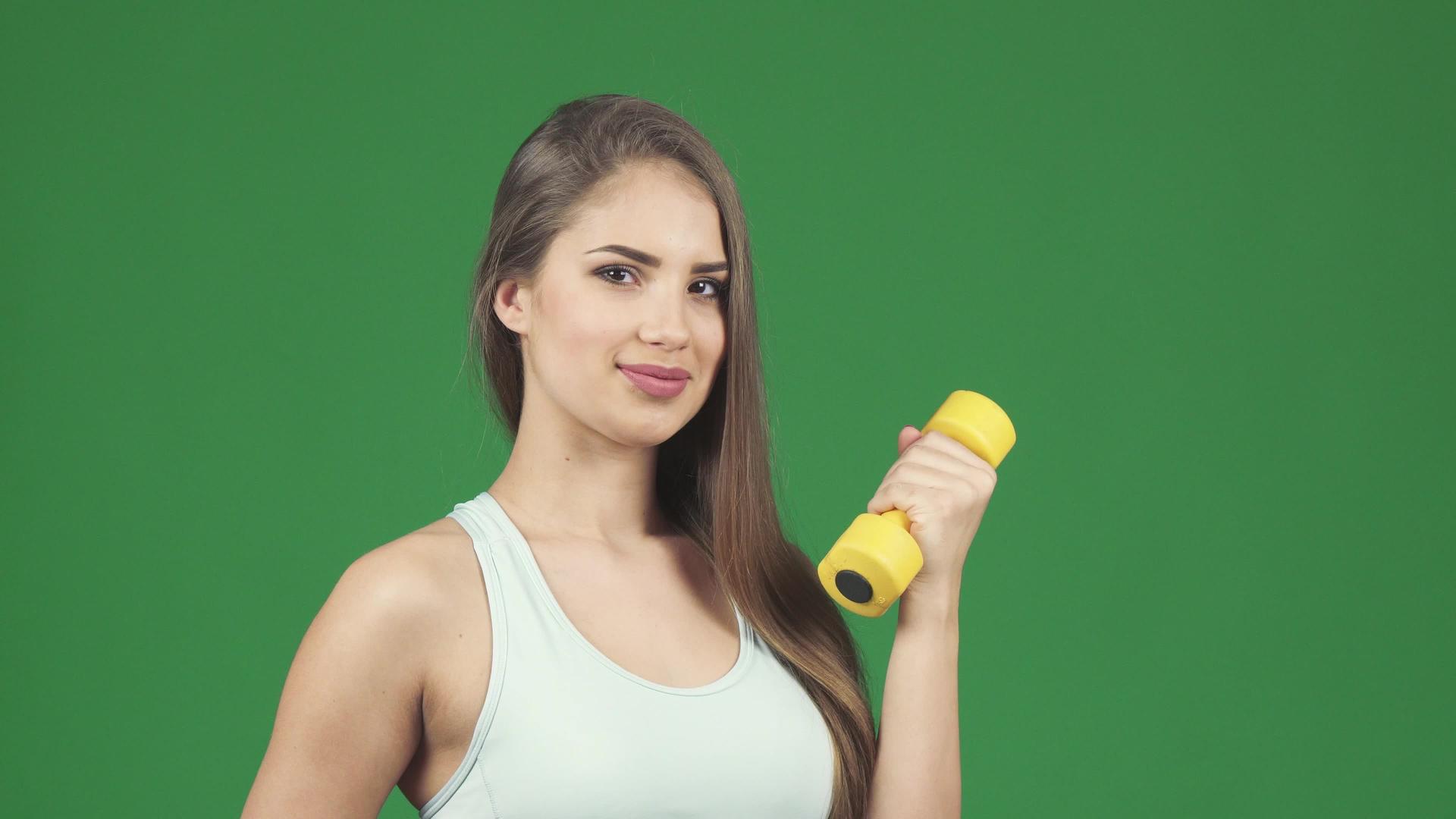 美丽的运动女运动员带着哑铃和一瓶水的微笑视频的预览图