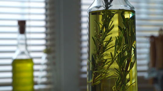含有迷迭香的橄榄油迷迭香药草落入橄榄油瓶中视频的预览图
