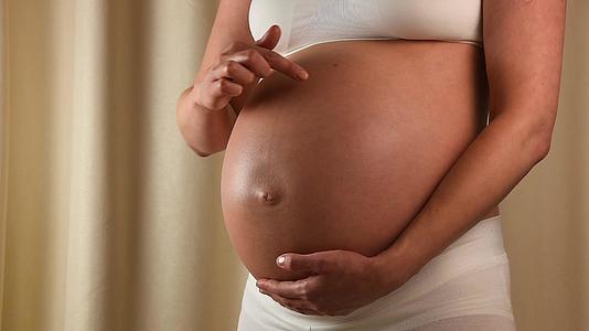孕妇用手抚摸她的腹部视频的预览图