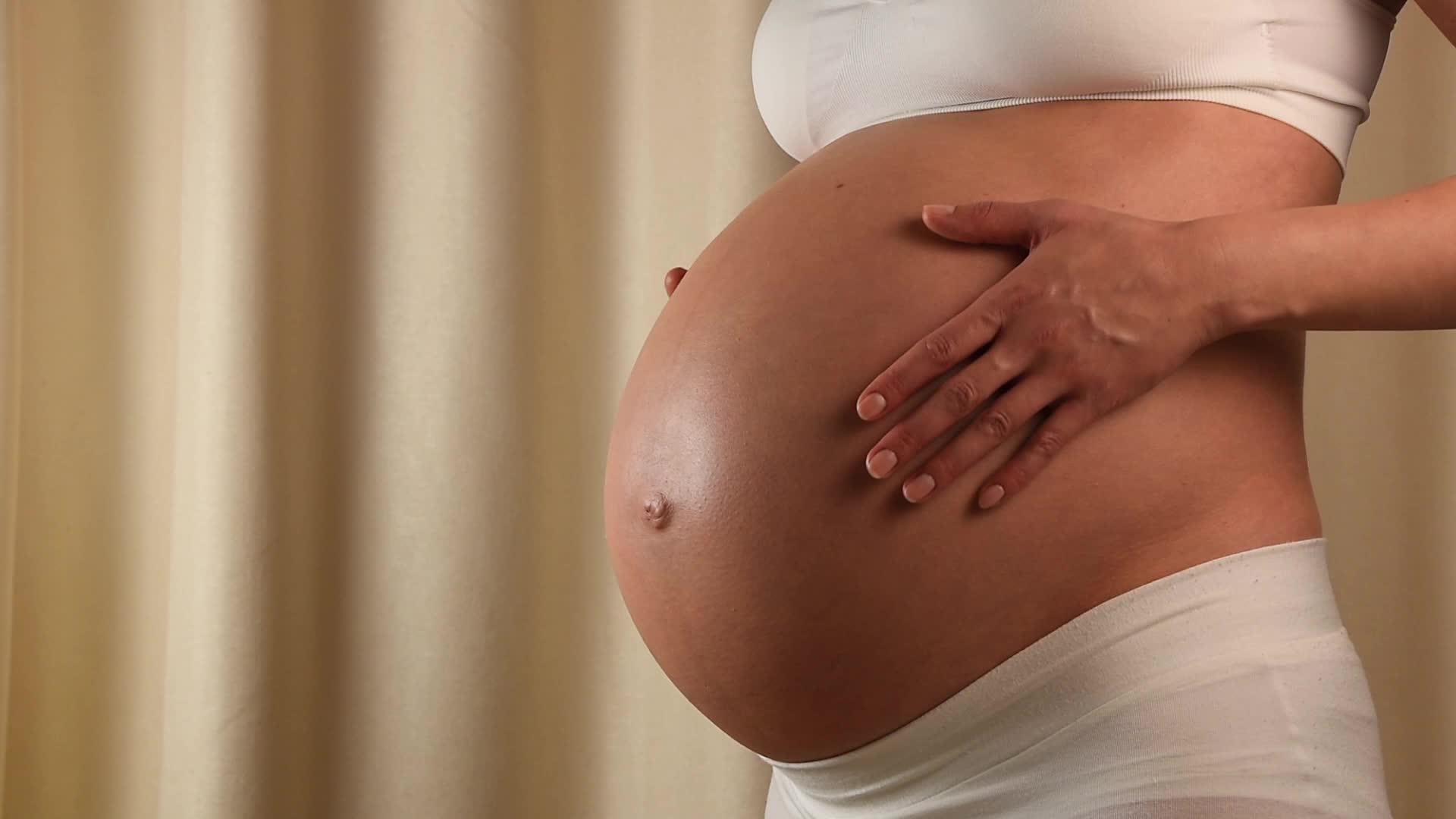 孕妇用手抚摸她的腹部视频的预览图