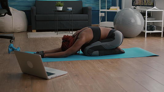 坐在瑜伽地图上做健身早期运动的黑皮肤弱女性视频的预览图