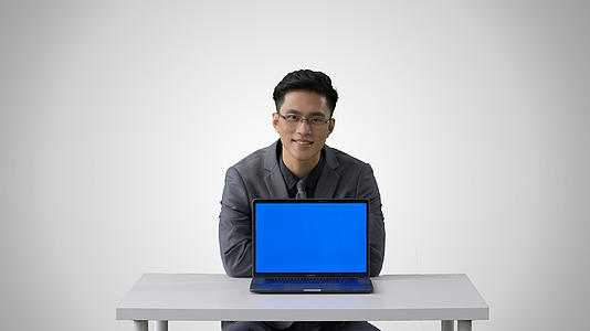 4k灰底穿西装的商务男性展示笔记本电脑形象视频的预览图