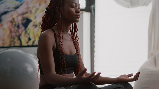在家做瑜伽时穿运动服的黑皮肤女运动员视频的预览图