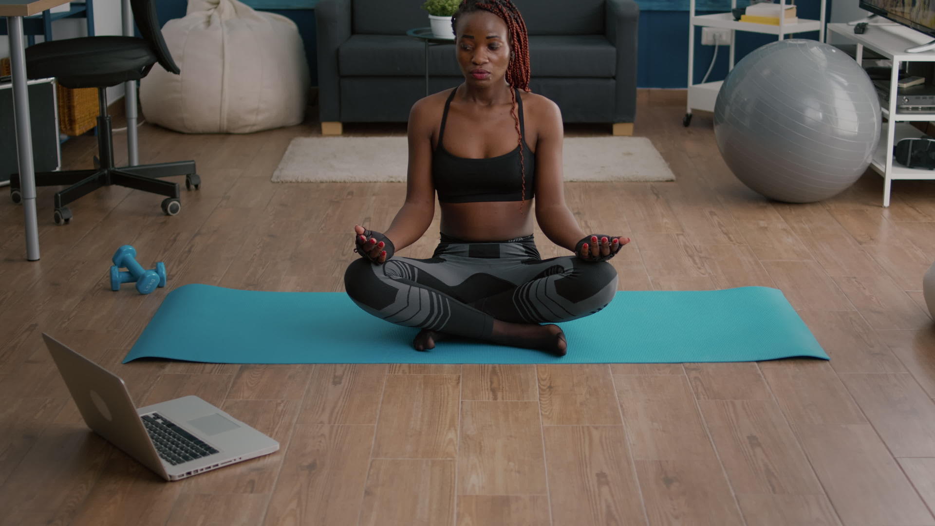 柔软的黑人女性坐在客厅瑜伽地图上的荷花位置视频的预览图