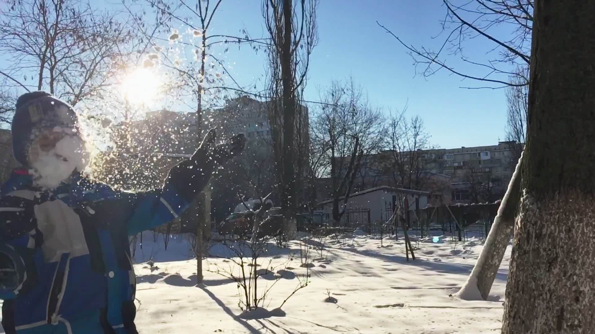 冬天男孩在空中扔雪无忧的孩子玩雪视频的预览图