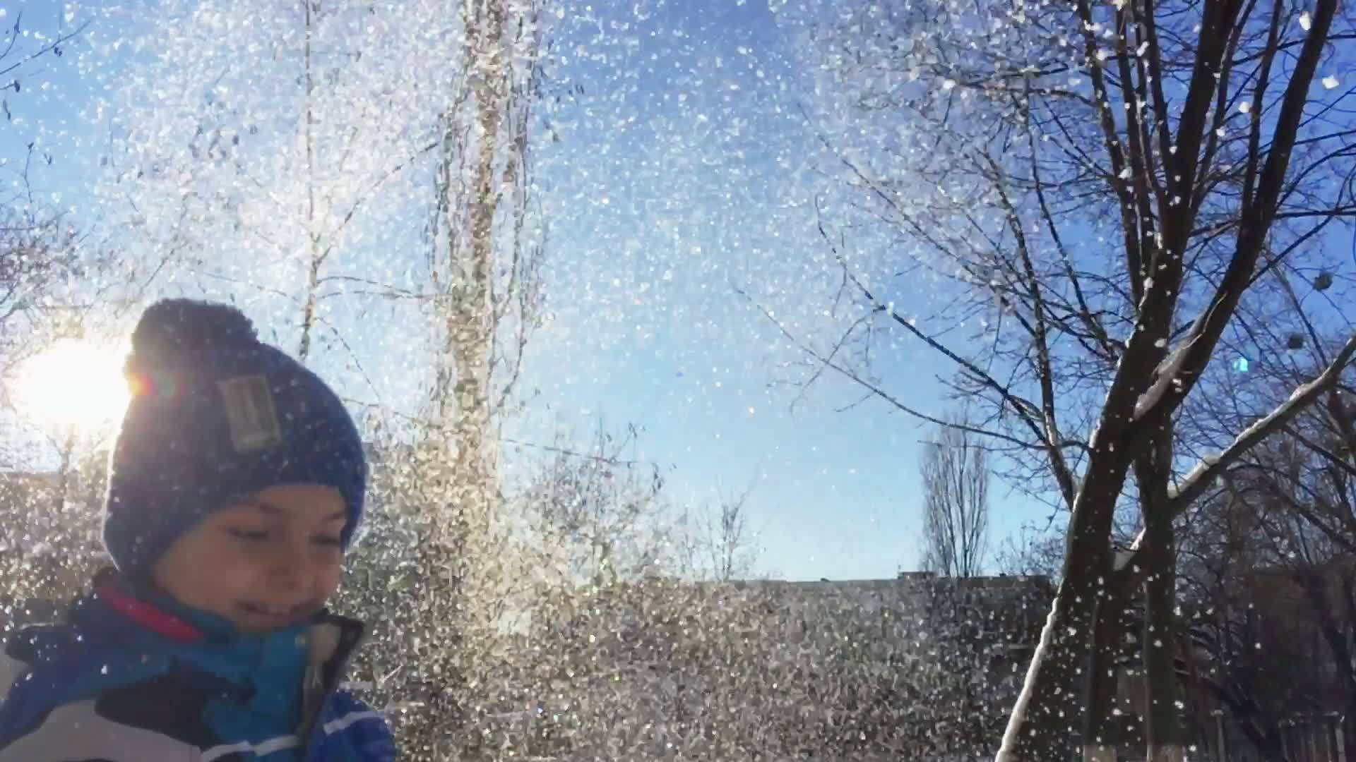 男孩在空中扔雪小男孩在玩耍视频的预览图