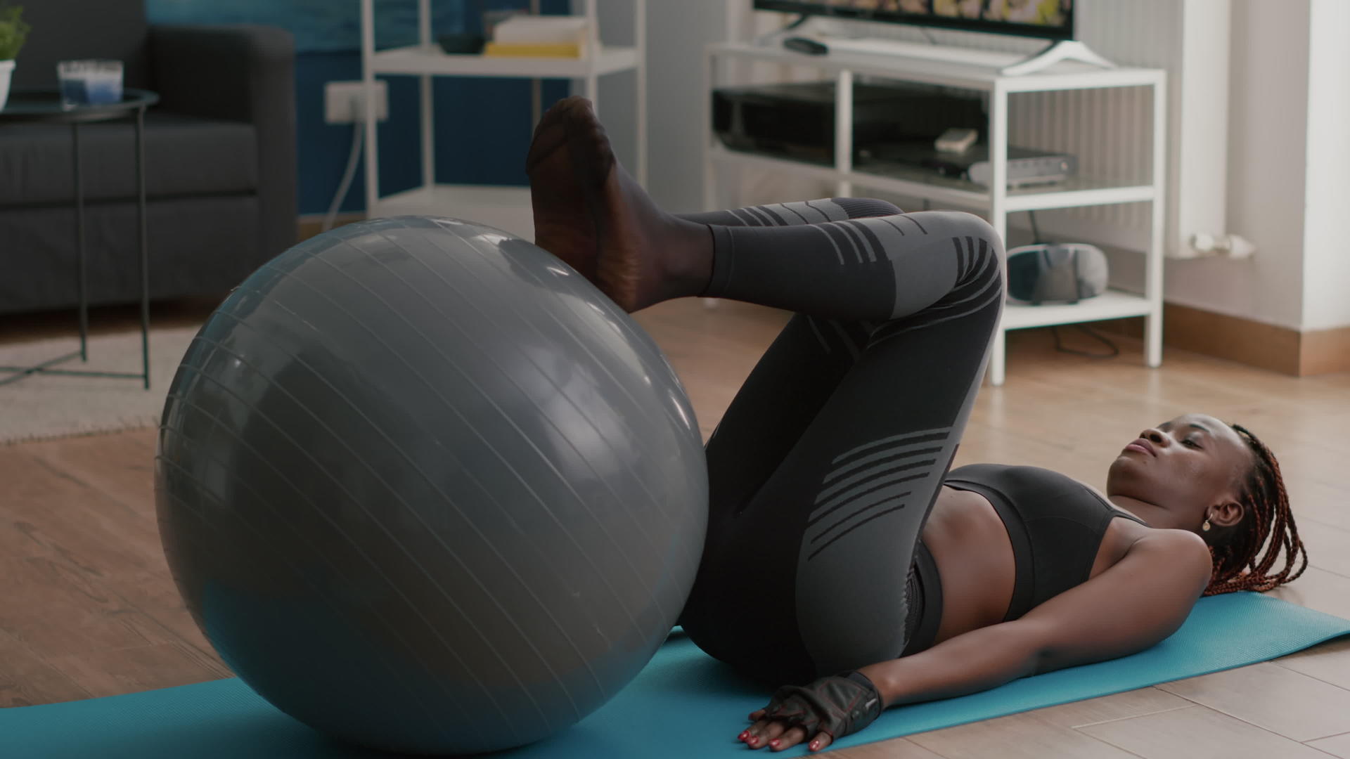 女色皮肤的女性使用身体球伸展腹部肌肉进行腹部肌肉锻炼视频的预览图