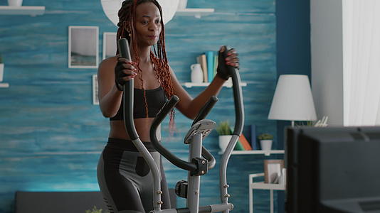 强壮的黑人女性骑着椭圆形自行车视频的预览图