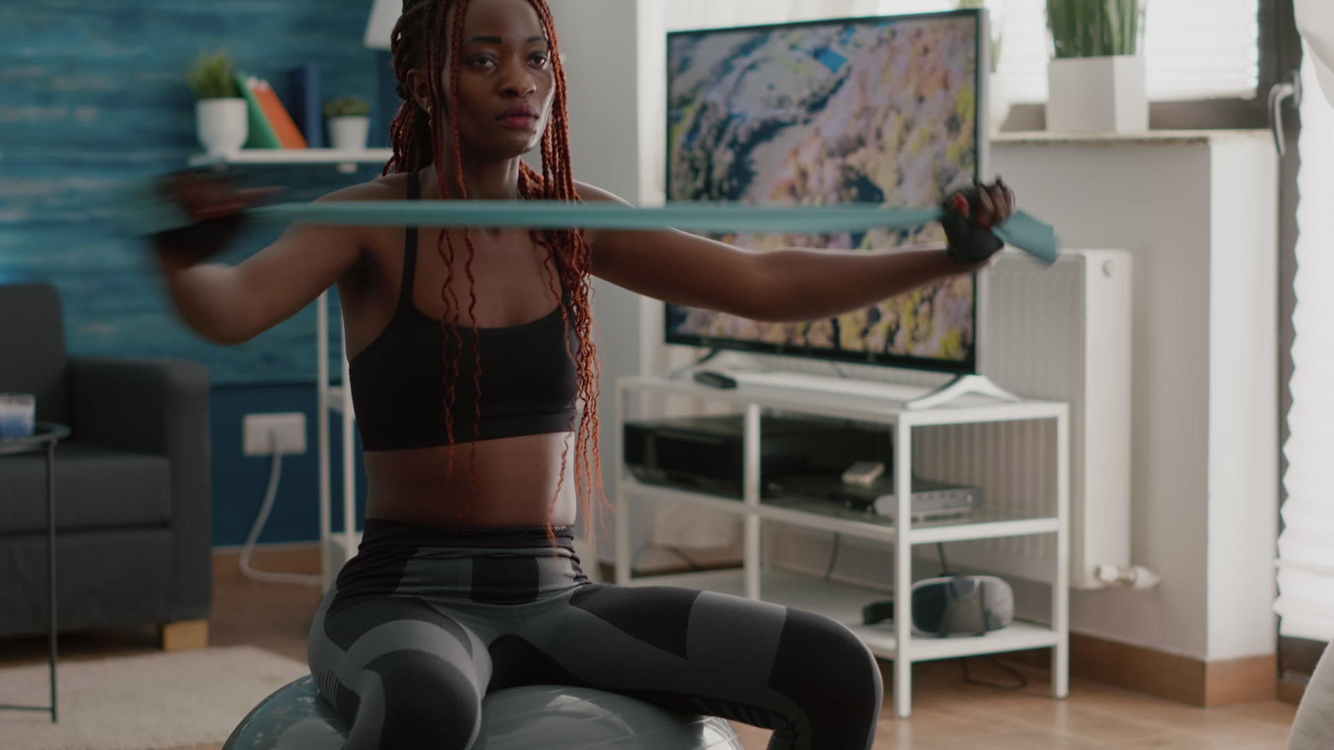 在健身球上用瑜伽乐队做瑜伽的黑人女性视频的预览图