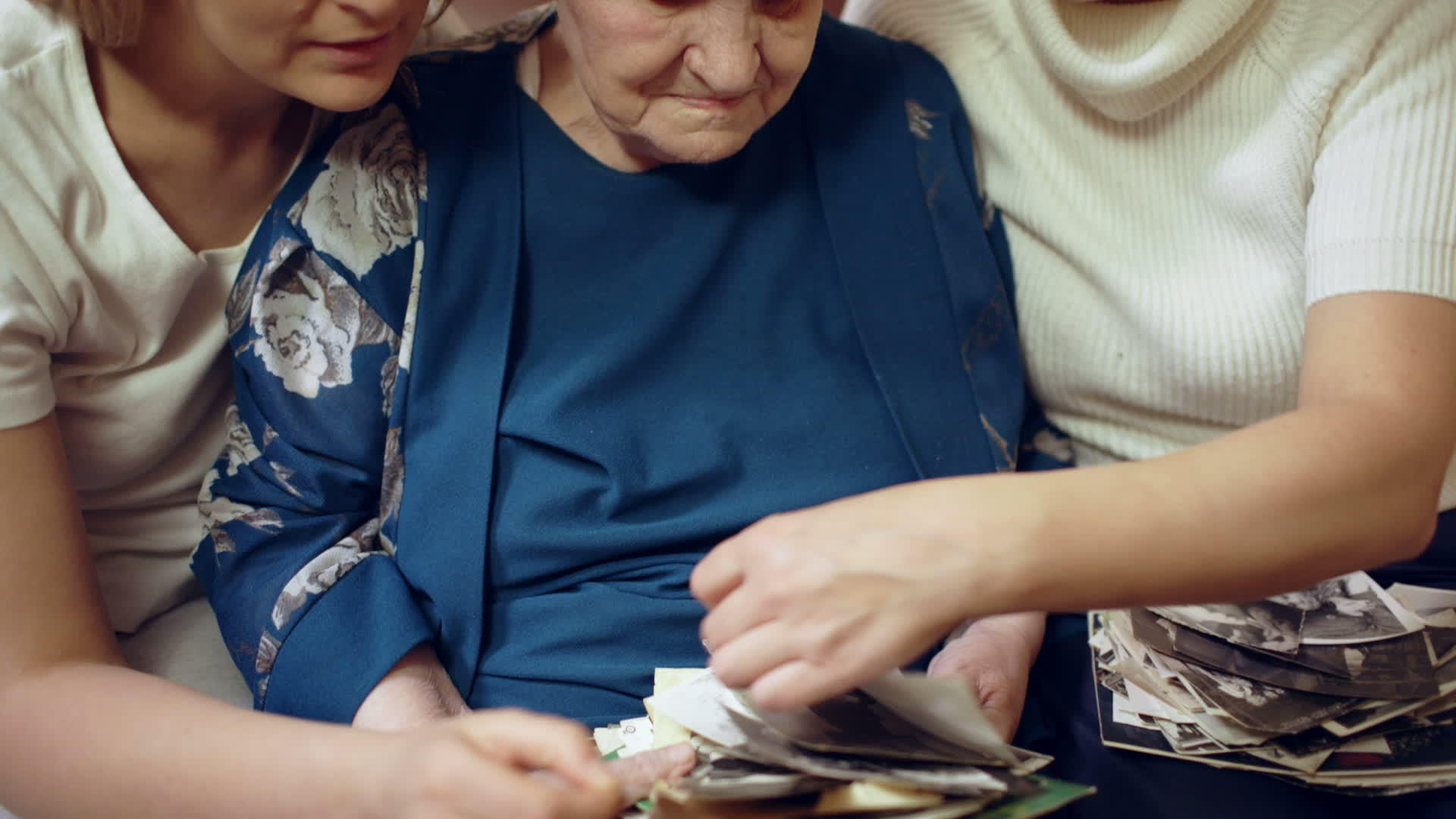 不同年龄的妇女通过旧家庭照片看老家庭照片视频的预览图