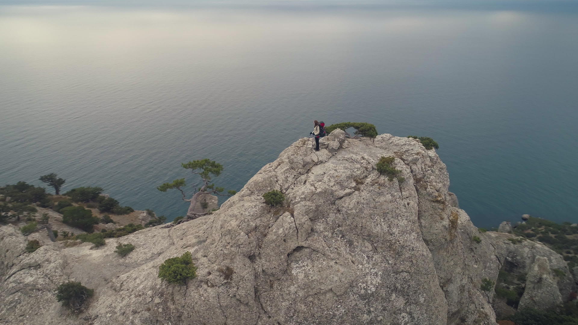站在岩石悬崖顶上的年轻女子靠近海岸线视频的预览图