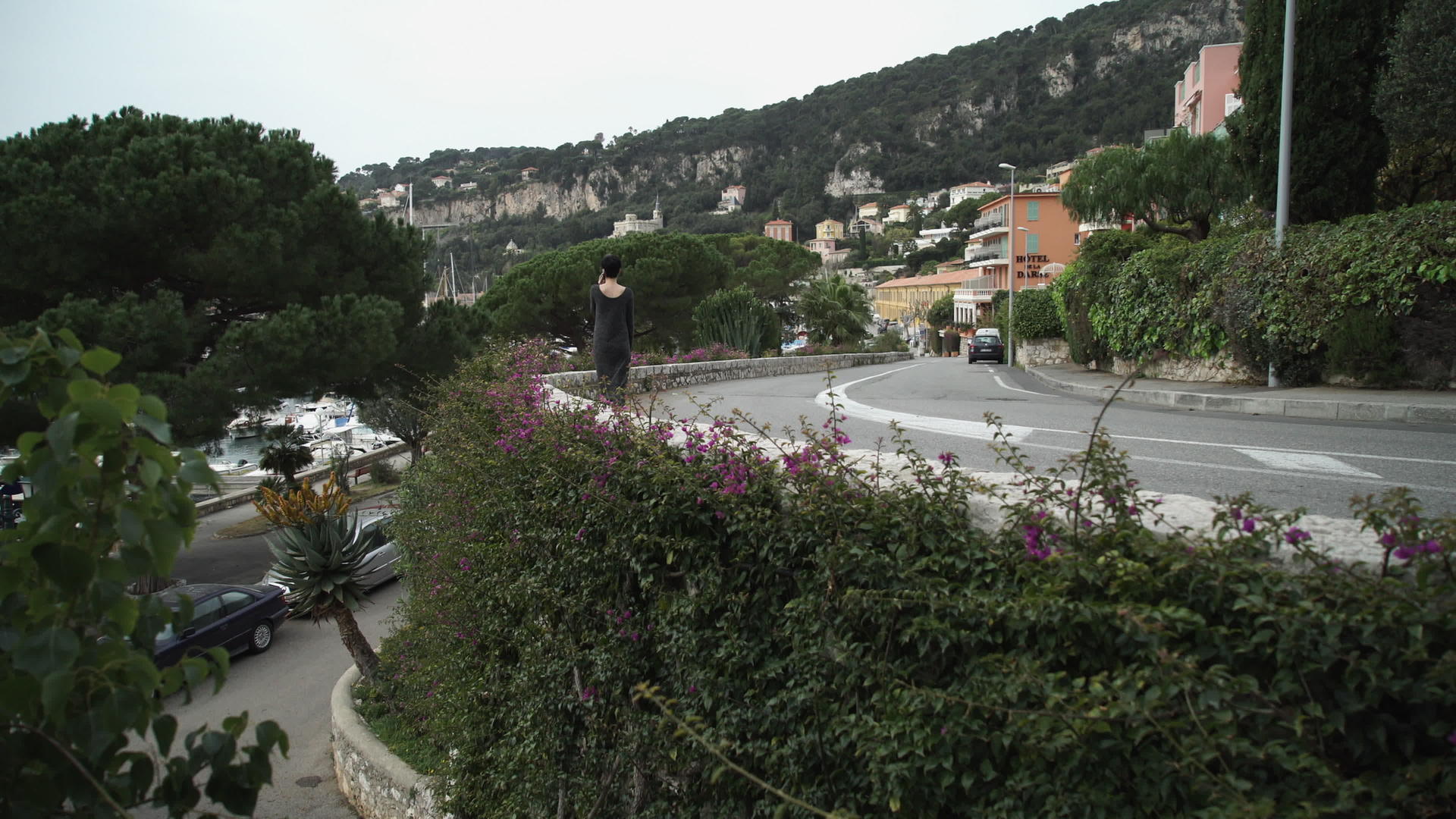 妇女沿着地中海城市的绿树和鲜花公路行走视频的预览图
