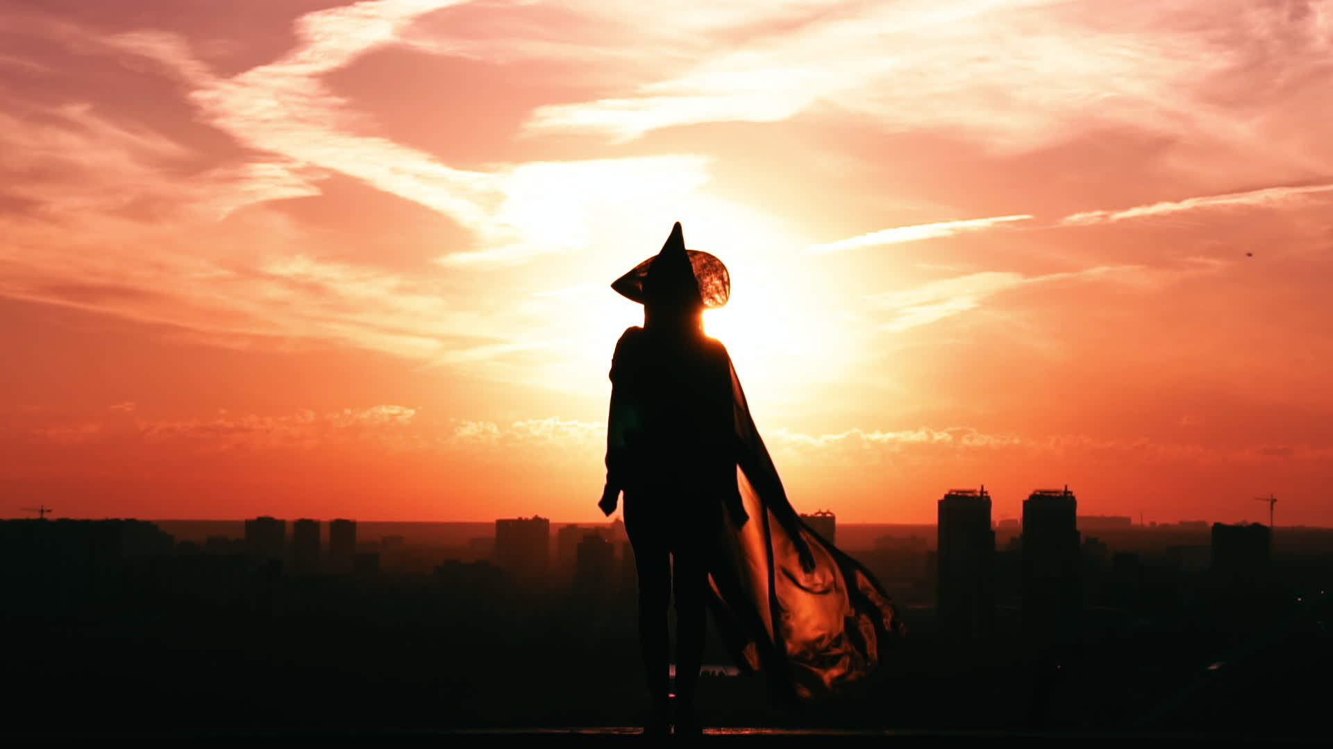 女孩戴着女巫帽和闪闪发光的斗篷城风景慢动作视频的预览图