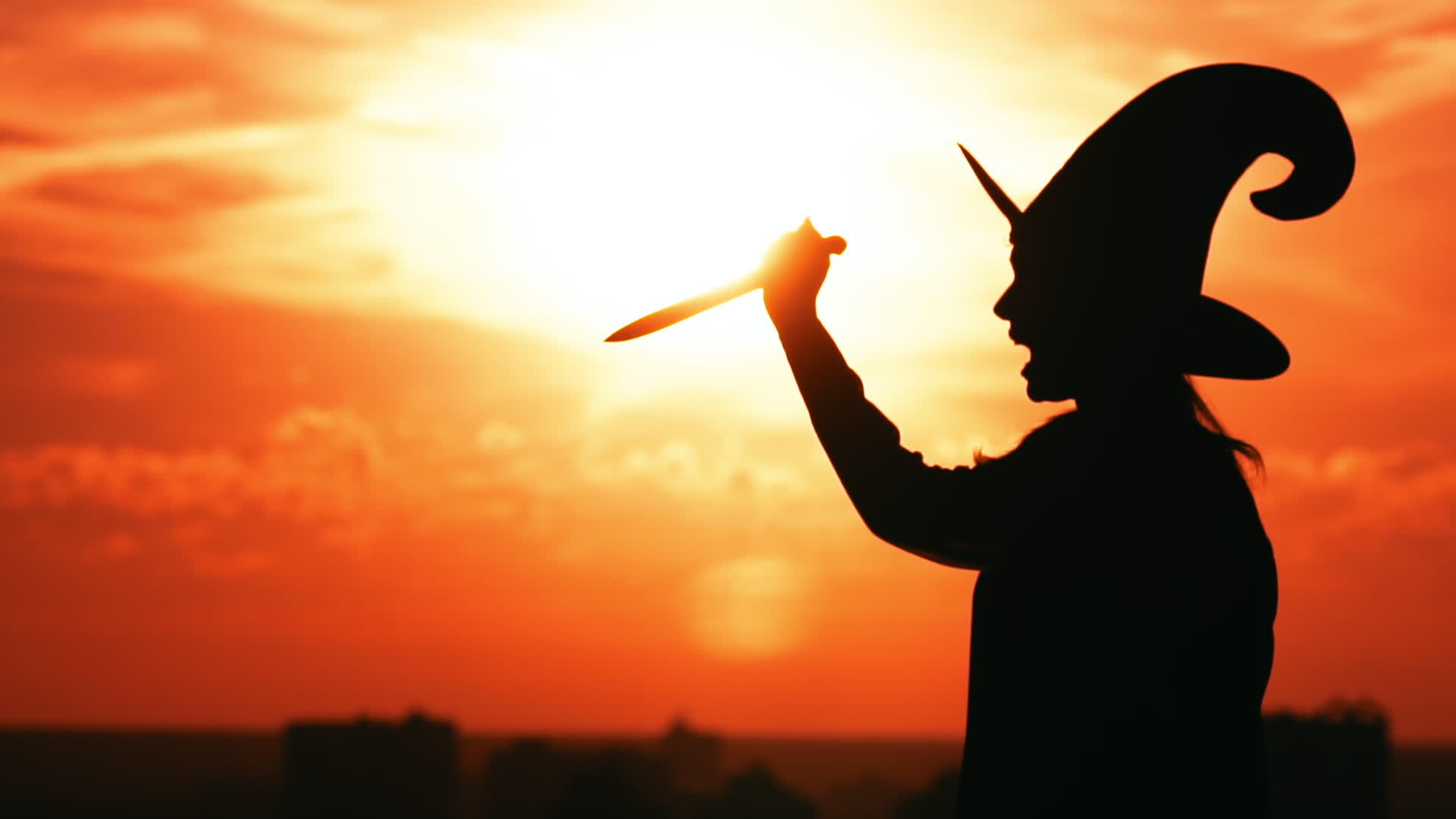 穿着巫服的女孩举起一把刀看着城市风景视频的预览图