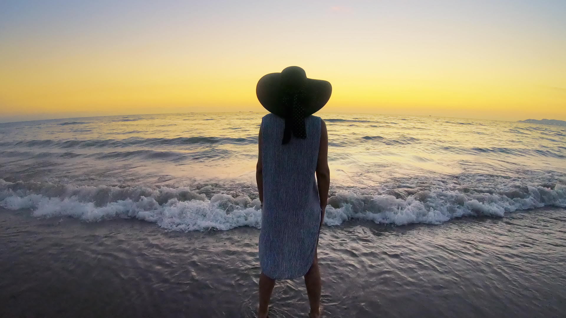 悲伤和孤独的女人在日落时站在海滩上视频的预览图